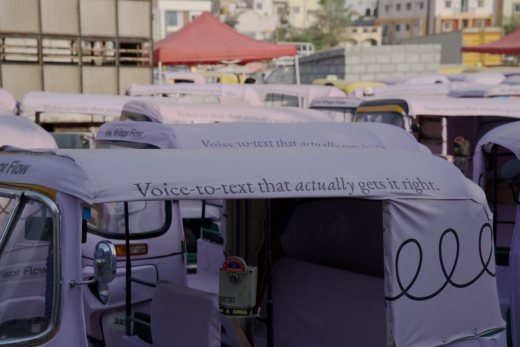 A branded auto-rickshaw driving through Bengaluru, close up of the roof tagline